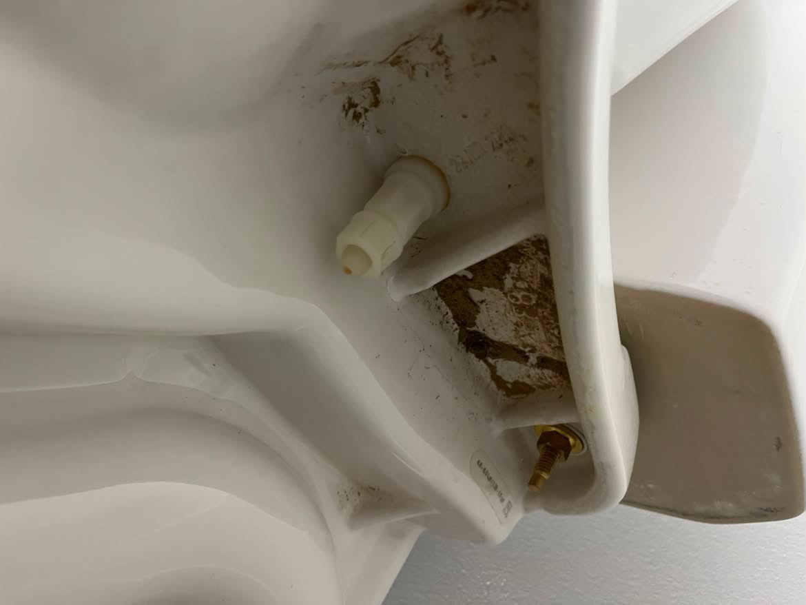 Before: grimy buildup under a toilet tank